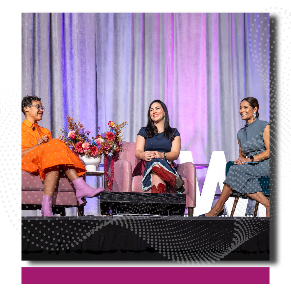 Three women seated on pink armchairs on a stage during the 2024 Annual Luncheon. They include the VP of Development, Renee Ferrufino, Jordan Castteel, and Kali Fajardo-Anstine. The backdrop features light-colored curtain with purple lighting. On the left,